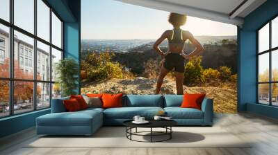 fit african american woman hiking runyon canyon stopping to see view of sunset Wall mural