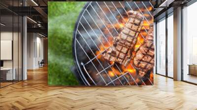 grilling steaks on charcoal kettle grill outdoors in yard shot from top view with copy space composition Wall mural