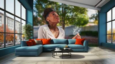 happy african american woman smoking marijuana joint in back yard Wall mural