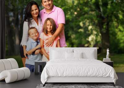 happy family of four posing outside Wall mural