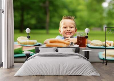 happy little boy at picnic table loaded with food Wall mural