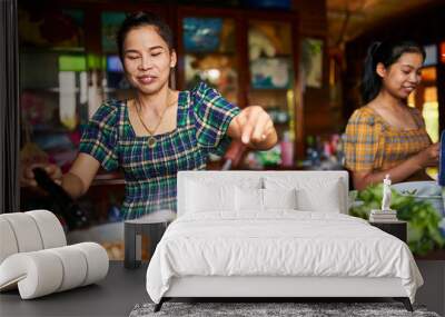 thai mother and daughter cooking together in rustic kitchen making red curry Wall mural