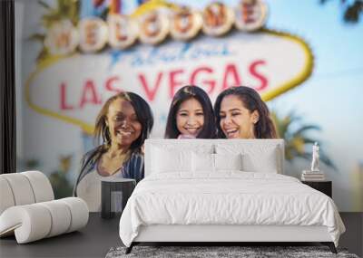 three girls on vacation taking selfie in front of welcome to las vegas sign Wall mural