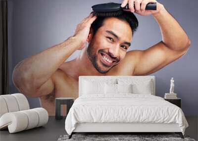 Portrait, beauty or happy man brushing hair in grooming with salon haircare product on studio background. Smile, brush or confident healthy Asian male model with cool hairstyle in morning routine Wall mural