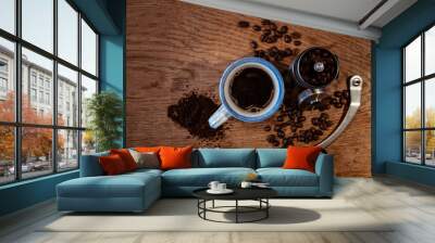 Coffee in Mug surounded by coffee beans and hand grinder on wood Wall mural