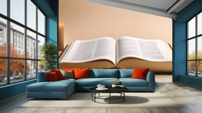 lightful christian open bible with candle beside it on beige background and copyspace Wall mural