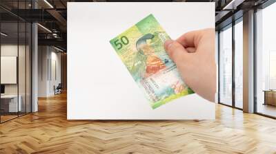 Man holding 50 CHF Swiss franc banknote paper currency isolated on white background Wall mural