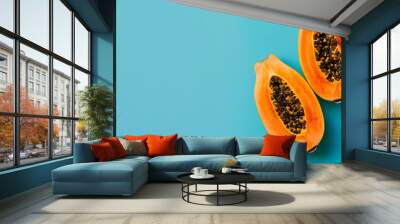 Two halves of a pumpkin on a blue background, isolated in the foreground. Wall mural