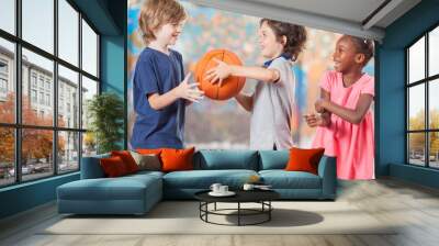 Happy multi ethnic children playing basketball at school Wall mural