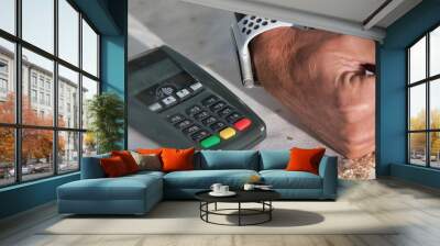 Mirror reflection of  contactless payment. Man approaching smartwatch to portable machine Wall mural