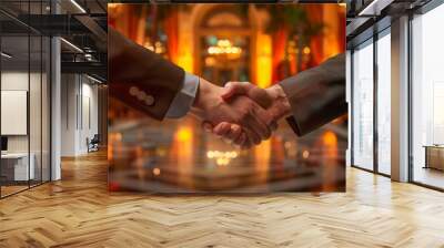 Close-up image of two businessmen shaking hands in a hotel lobby Wall mural