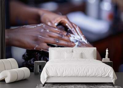 Hands of an African Nigerian stylist combing and applying relaxer cream to the hair of a woman in saloon Wall mural