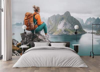 Woman traveler hiking in Norway girl backpacker relaxing on mountain cliff edge in Lofoten islands female tourist traveling outdoor alone healthy lifestyle summer vacations adventure trip  Wall mural