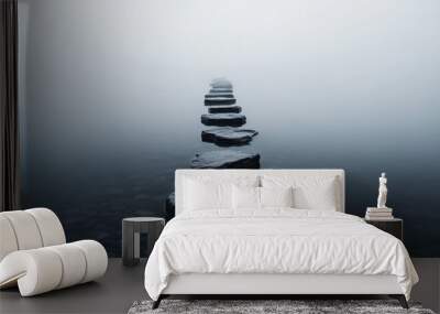 A series of wet, dark stepping stones stretches into the dense fog over calm water, creating an ethereal and mysterious atmosphere. Wall mural