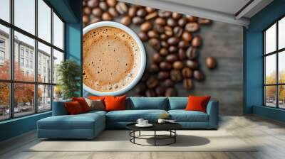 A steaming cup of fresh coffee sits amid scattered coffee beans on a rustic wooden table, highlighting the richness and aroma of the coffee experience. Wall mural