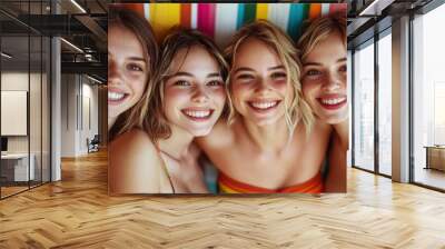 Four women show their beautiful smiles in a colorful and vibrant setting, each with unique hairstyle and style, radiating joy and positive energy together. Wall mural