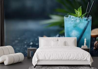 This image depicts a cool blue cocktail with mint leaves and ice, beautifully presented on a dark table, creating a contrast that highlights the drink’s refreshing and appealing nature. Wall mural