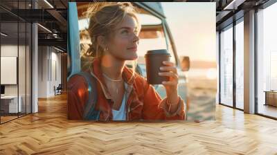 A female holding a coffee cup by vintage camper van at sea beach in summer vacation Wall mural