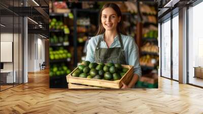 Female worker carrying a crate of fresh avocado fruit in store Wall mural