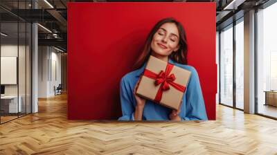 Happy female with gift box in holiday season. Wall mural