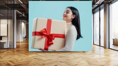 Happy female with gift box in holiday season. Wall mural