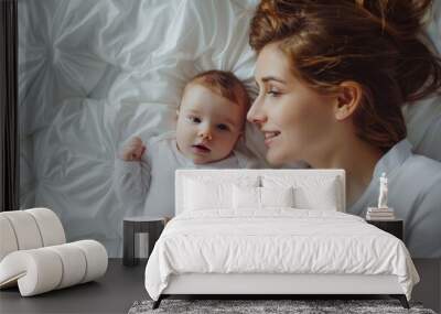 Happy mom with smiling cute baby in bed. Wall mural