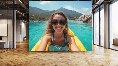 Portrait of a happy female in kayak boat exploring rocky valley in shallow sea Wall mural