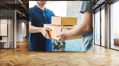 Delivery concept Asian Man hand accepting a delivery boxes from professional deliveryman at home Wall mural