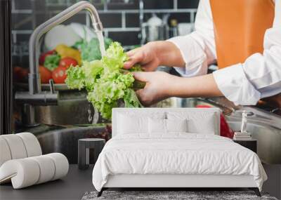 Hand of maid washing tomato fresh vegetables preparation healthy food in kitchen Wall mural