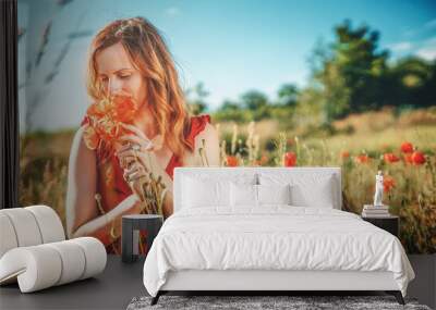 portrait of a beautiful young woman holding bouquet of red poppies. Wall mural