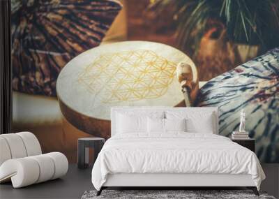 shamanic drum at home on the couch. The flower of life is drawn on the drum. Wall mural