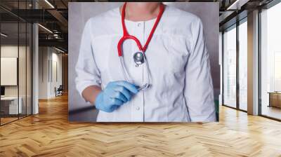 female doctor in white coat and gloves with stethoscope Wall mural