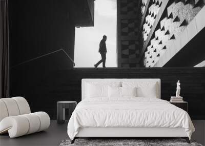 silhouette of a walking man in a city. black and white photo Wall mural