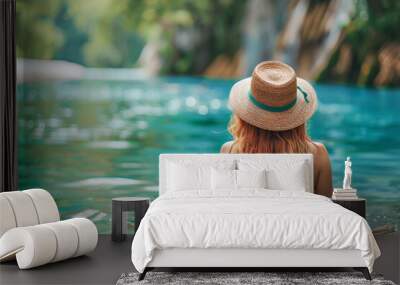 Tourist relaxing in water with hat at krka national park Wall mural