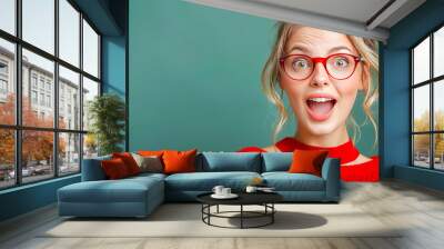 Young woman wearing glasses is making a surprised face expression on a green background Wall mural