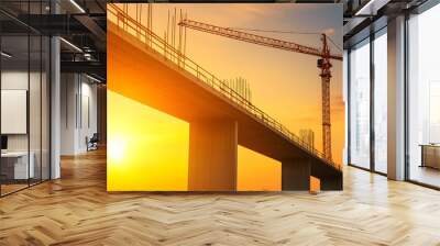 Large infrastructure project with cranes and scaffolding building a bridge, expansive construction site under warm evening light Wall mural