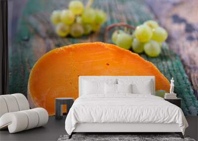 Piece of tasty mimolette cheese on white. Breakfast, chees. Wall mural