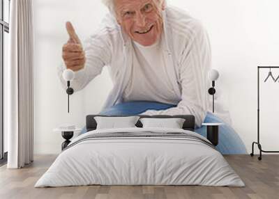 senior man holding thumb up on gym ball Wall mural