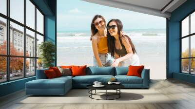 Two women friends in summer casual clothes Take a photo together at the beach Wall mural