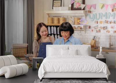 Two Women Preparing Fresh Meals in Cozy Kitchen for Online Food Business Wall mural