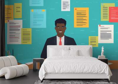 A man is sitting at a desk with a lot of papers around him Wall mural