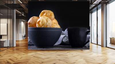 delicious cheese breads and a coffee mug on dark background Wall mural