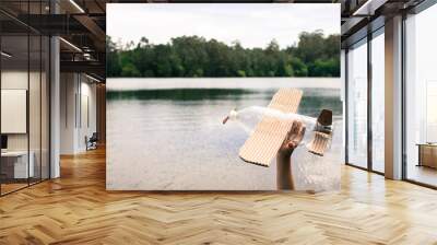 children's hands playing with a plane built with recycled material (wood, PVC bottles, cardboard) Wall mural