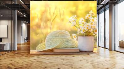 beautiful composition with chamomile flowers in Cup, old book, braided hat in summer garden. Rural landscape natural background with Chamomile in sunlight. Summertime season. copy space Wall mural