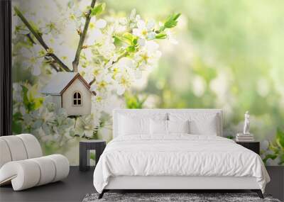 toy house on blossom cherry flowers, spring natural background. concept of mortgage, construction, rental, family and property. eco-home. spring season. template for design Wall mural