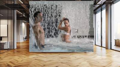 Man and woman exposing body under waterfall in pool Wall mural