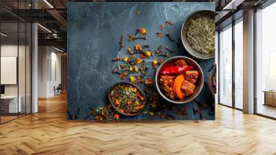 Assorted spices and herbs in bowls on dark slate background Wall mural