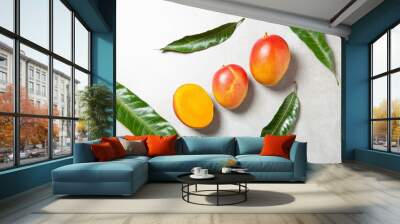 Top view of two and half mangos with four green leaves on a granite background Wall mural