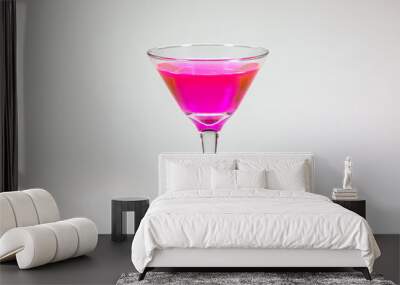 Halloween inspired Pink color cocktail in a clear glass sitting on a white table waiting to be enjoyed. Wall mural