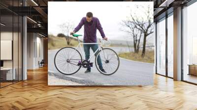 Cyclist man riding fixed gear sport bike in sunny day on a mountain road Wall mural